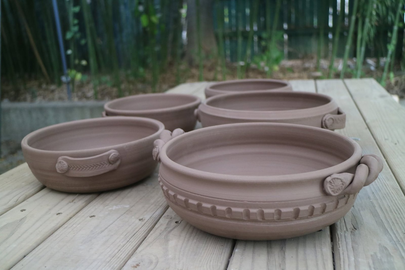 Hands shaping clay on a pottery wheel